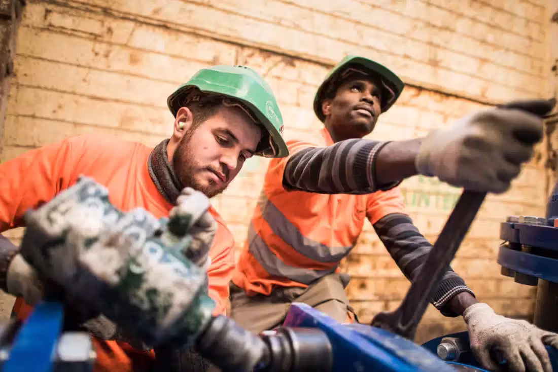 Deux ouvriers intervenant sur un équipement technique sur un chantier.