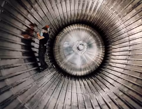 Technicien travaillant à l’intérieur d’une structure métallique cylindrique de grande dimension.